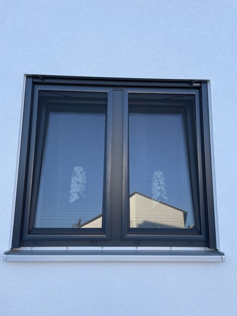 Spannrahmen-Fliegengitter an einem anthrazitfarbenen Doppelfenster